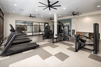 A spacious gym with treadmills, weights, and exercise equipment.